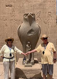 two people touch hands in front of sculpture