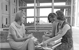 Three students sit on a bench in Stevenson Hall