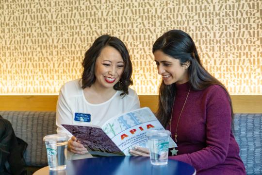 Two people looking at a magazine